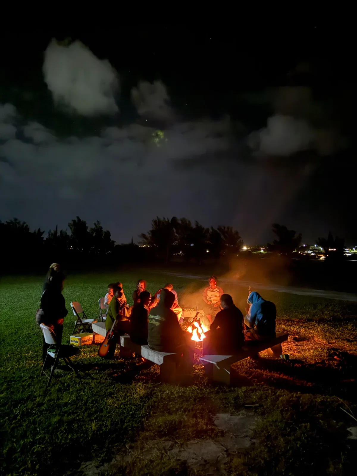Participants gathered around a glowing campfire at night
