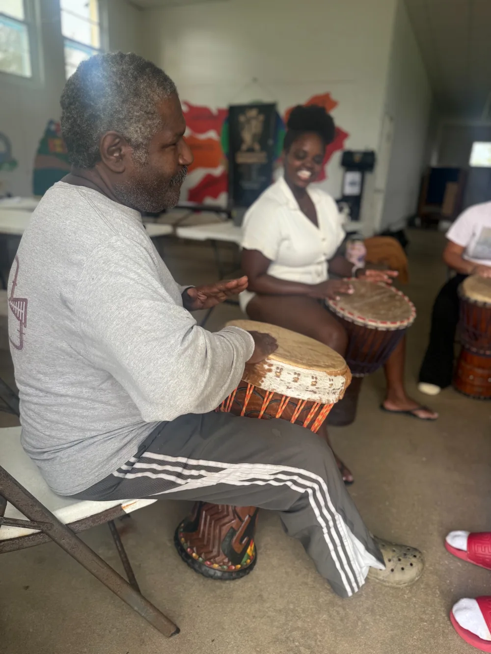 Participants playing hand drums together indoors